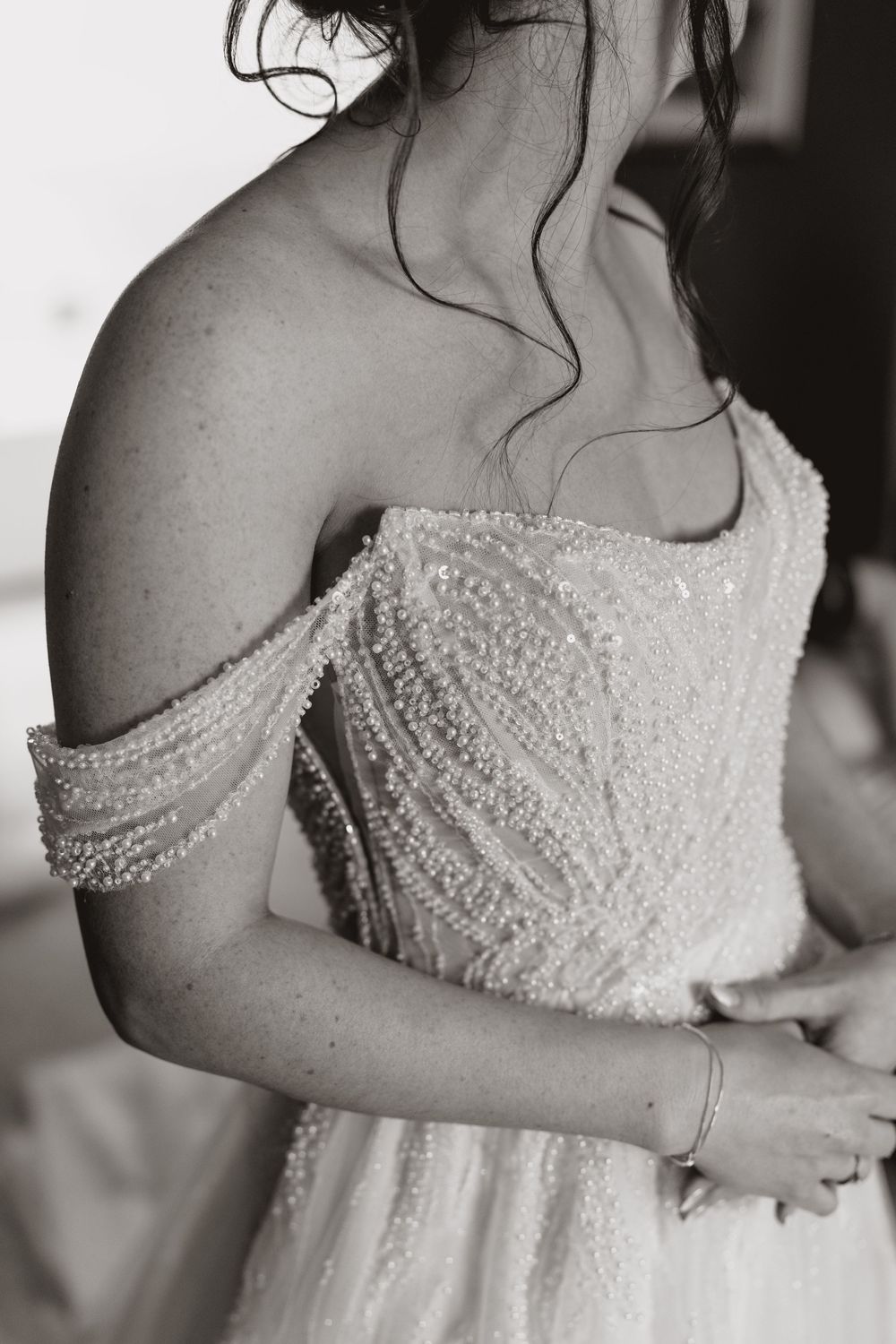 Close-up black and white photos of an intricately beaded wedding dress bodice.