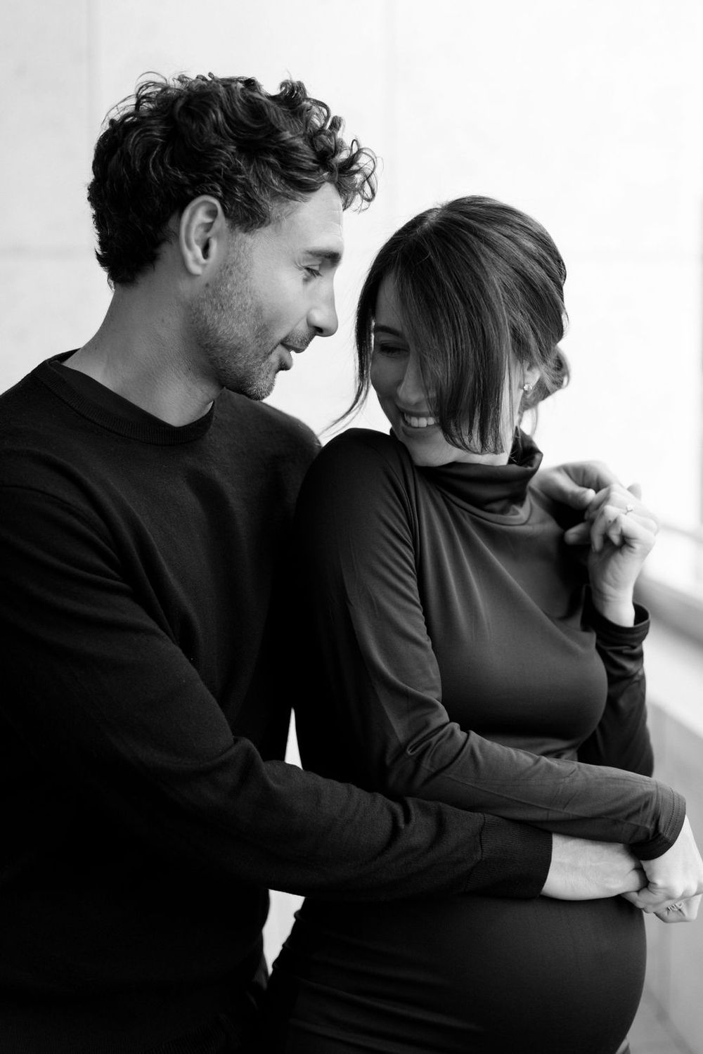 A series of intimate black and white photos showing a couple in dark clothing embracing and sharing tender moments.