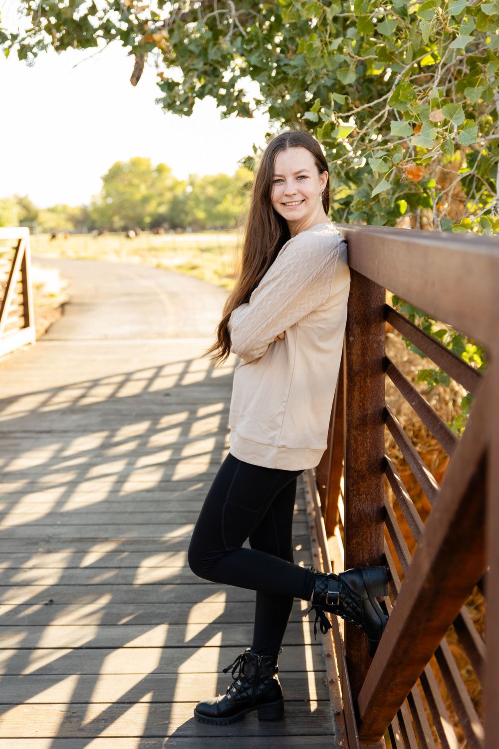 girl standing against hand rail of bridge