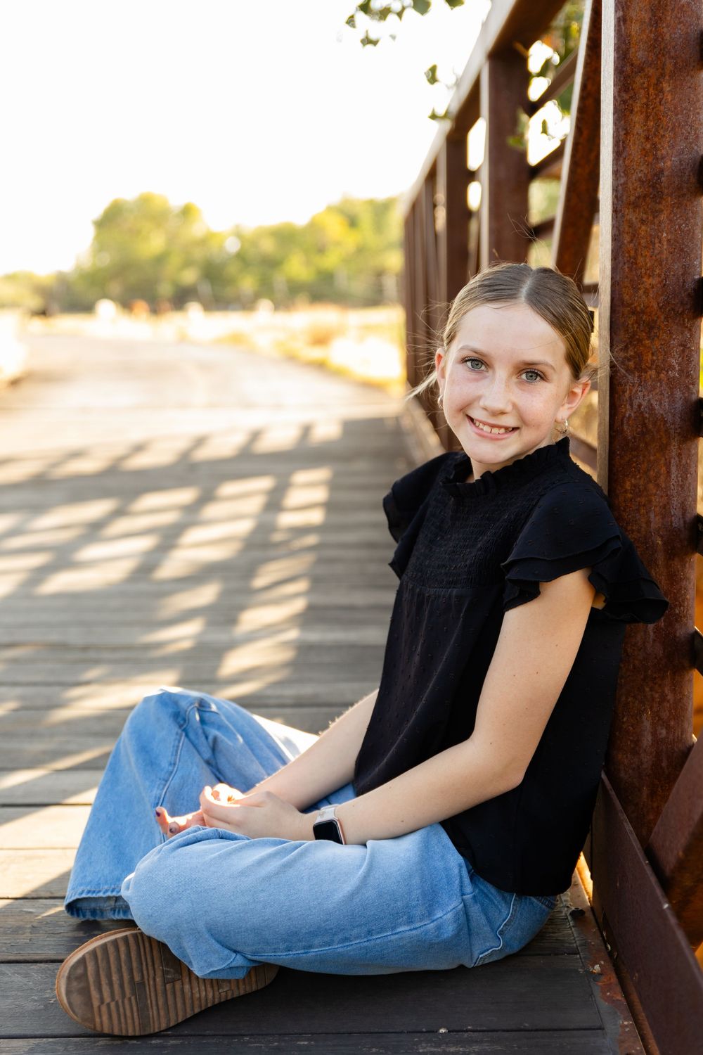 girl on bridge smiling at camera