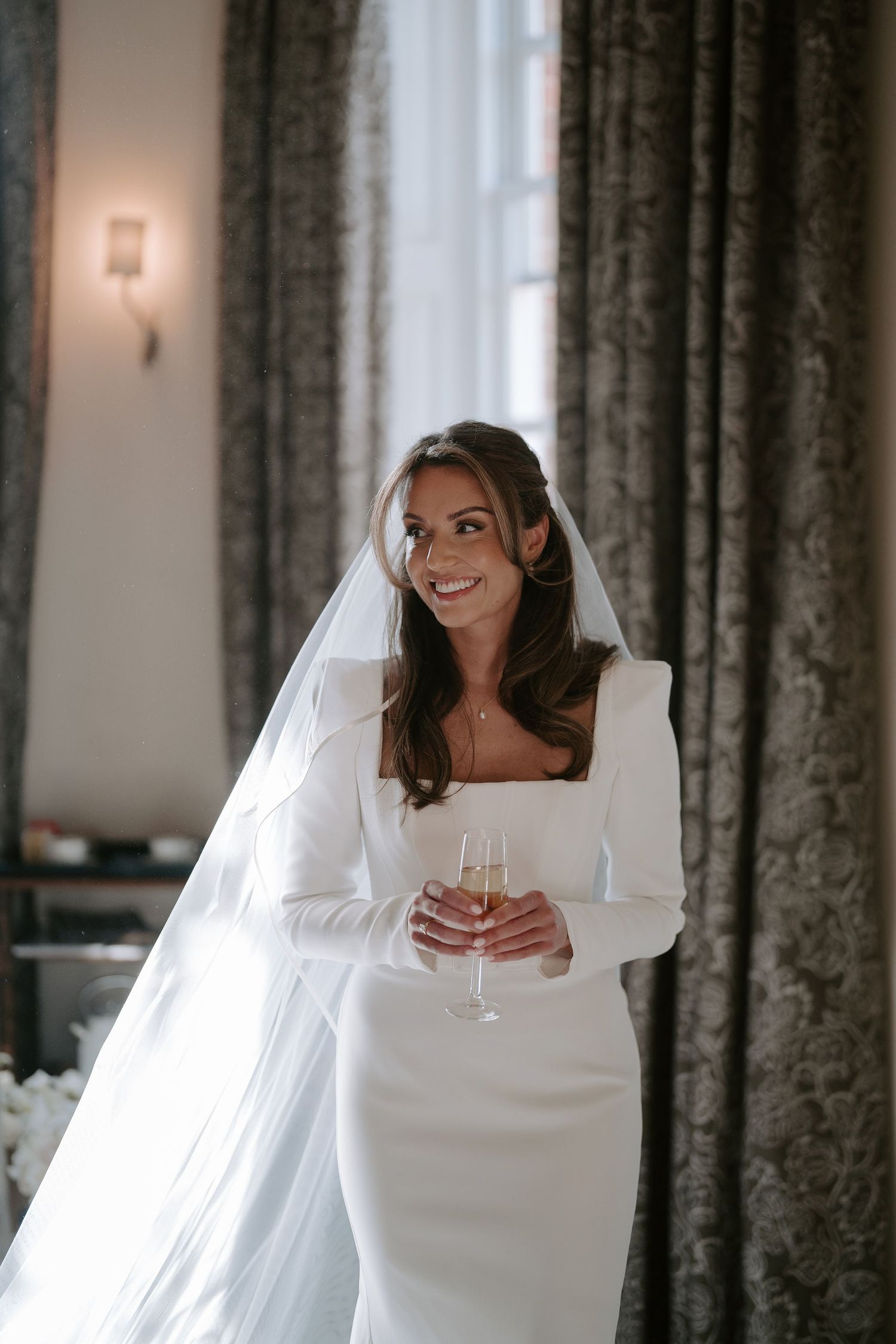 bride smiling and holding a champagne glass at Iscoyd park