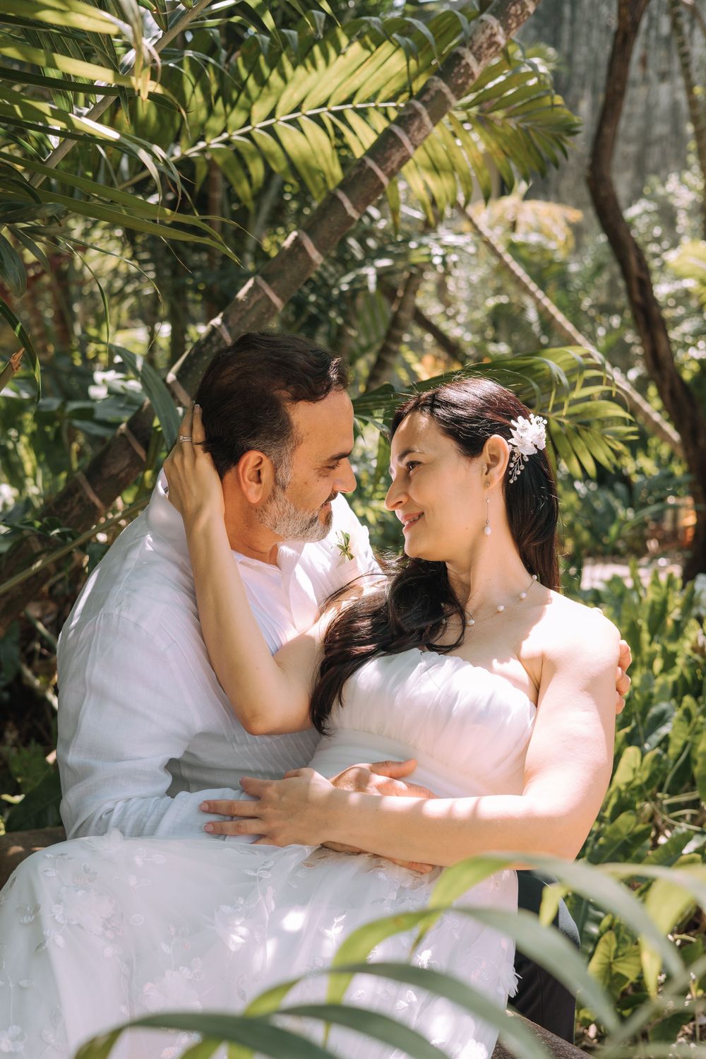 A romantic garden scene with lush tropical foliage and dappled sunlight filtering through the leaves.
