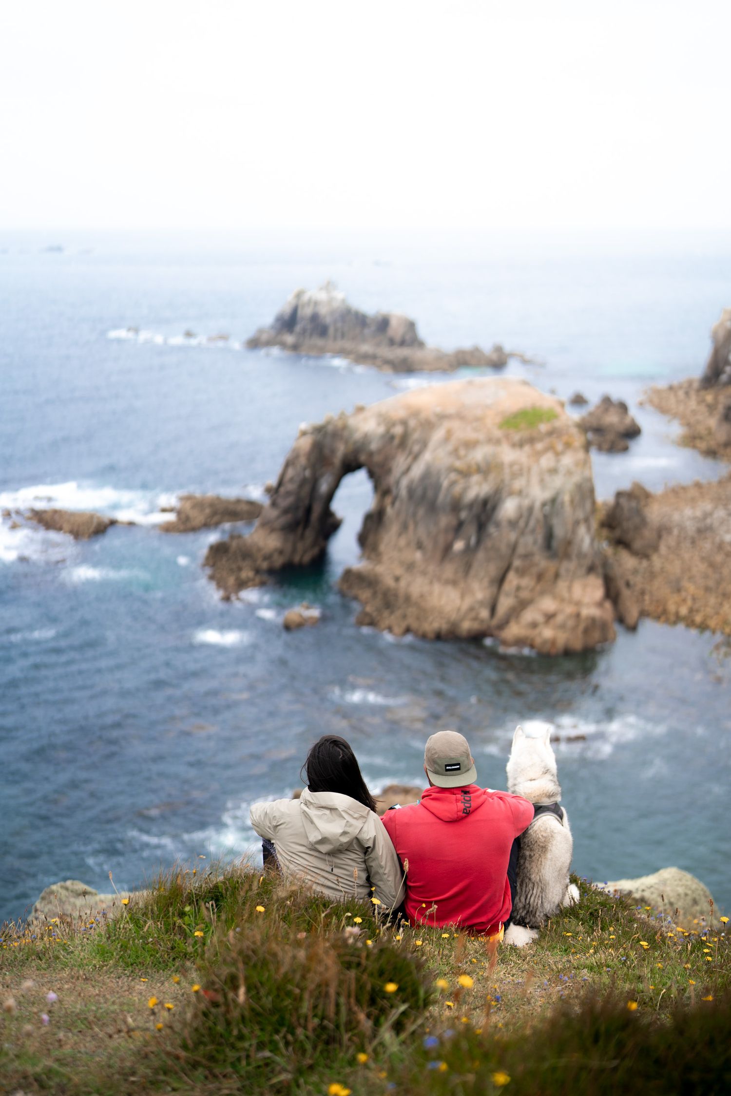 couple de randonneur avec chien devant l'arche de enys dodnan arch dans les cornouailles en angleterre