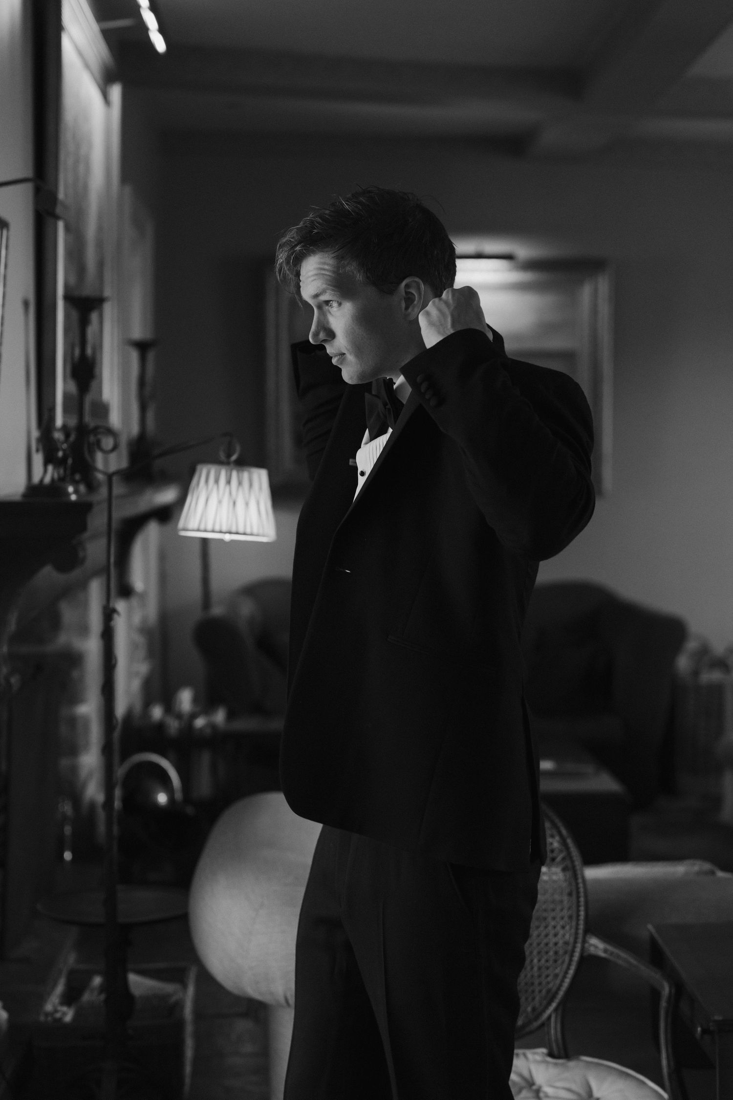 groom getting ready, putting on his jacket at dewsall court in herefordshire