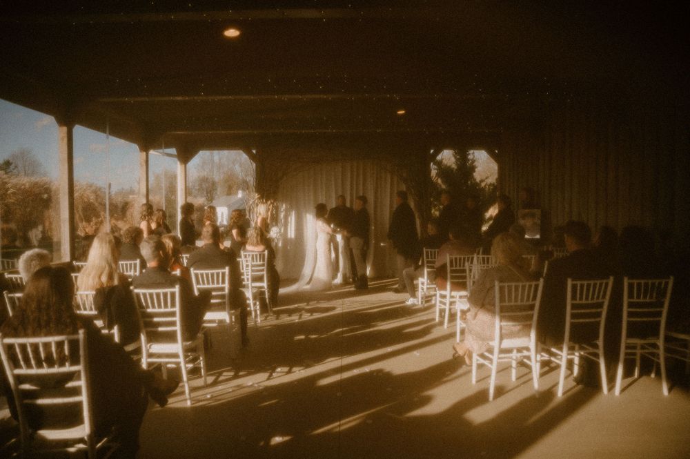 Vintage sepia-toned panoramic photo of empty chairs arranged in rows at an outdoor event venue.
