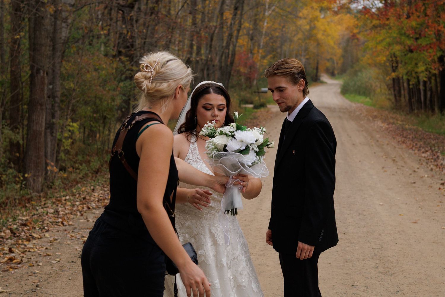 A Michigan photographer helps facilitate wedding portraits with the bride and groom and a venue in Michigan during fall.