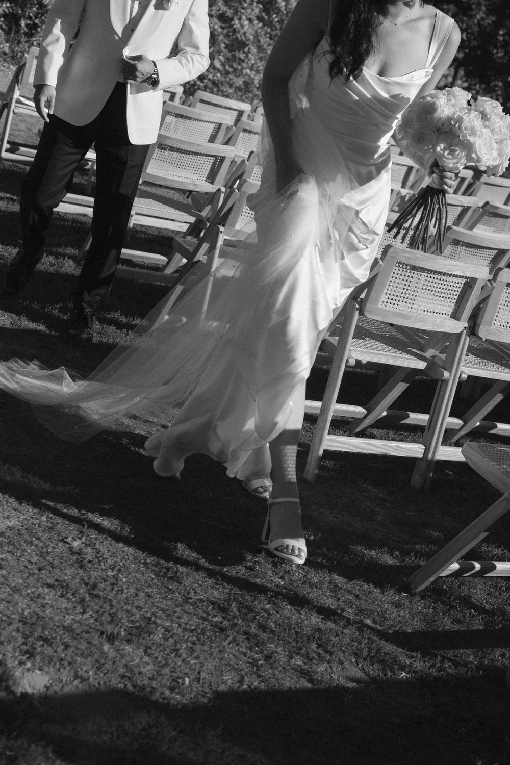 A series of black and white wedding photos showing the bottom portion of a bride's dress and shoes on grass.