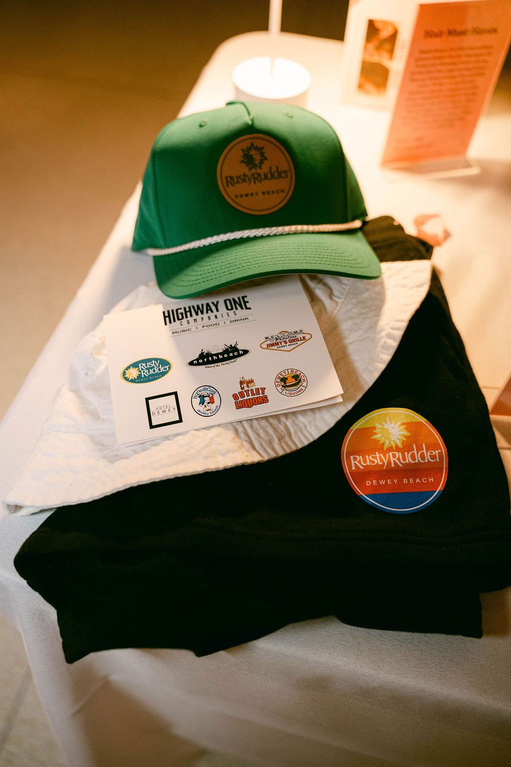 A collection of baseball caps with various logos and patches arranged in a row with warm lighting.