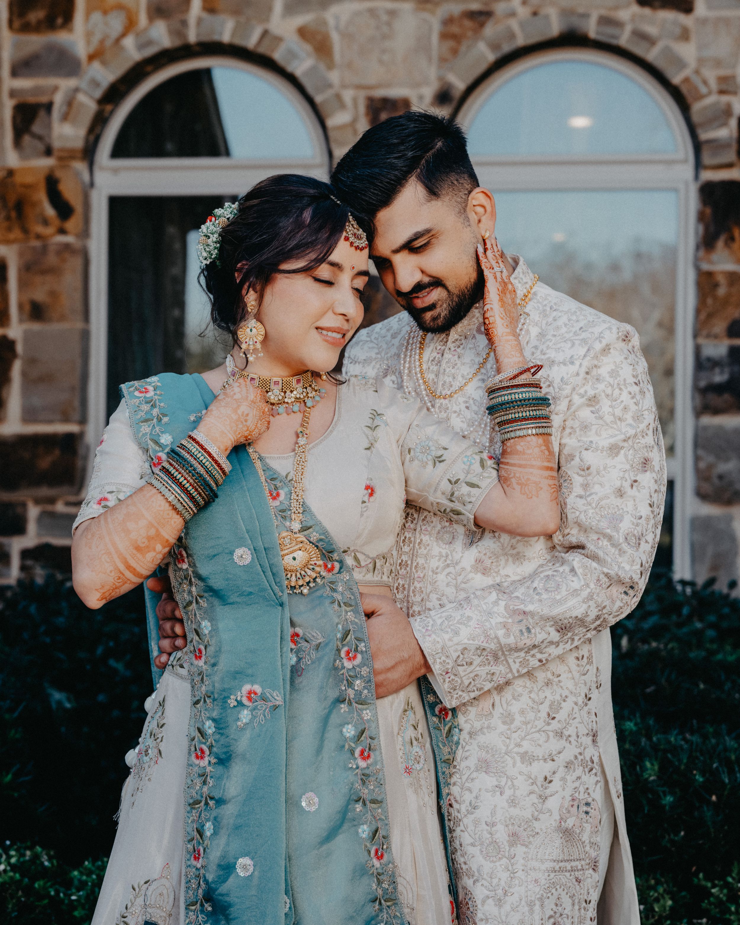 A couple in traditional South Asian wedding attire share intimate moments in a series of romantic outdoor portraits.