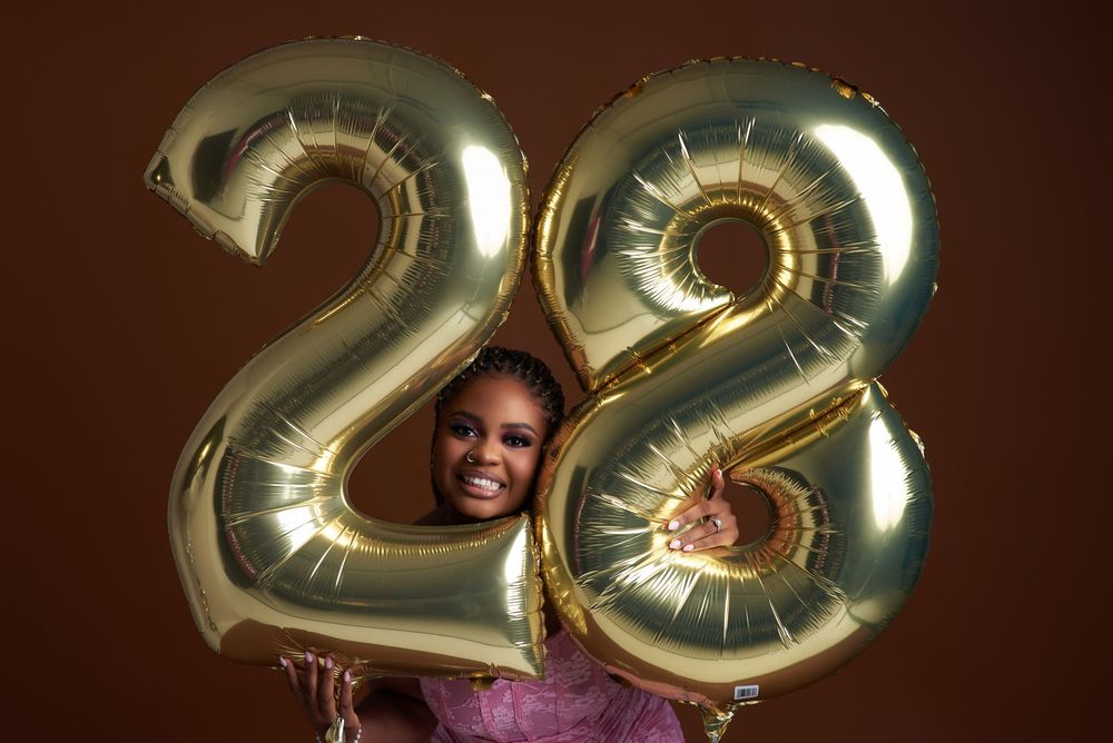 A large metallic gold number 22 balloon display against a dark brown background.