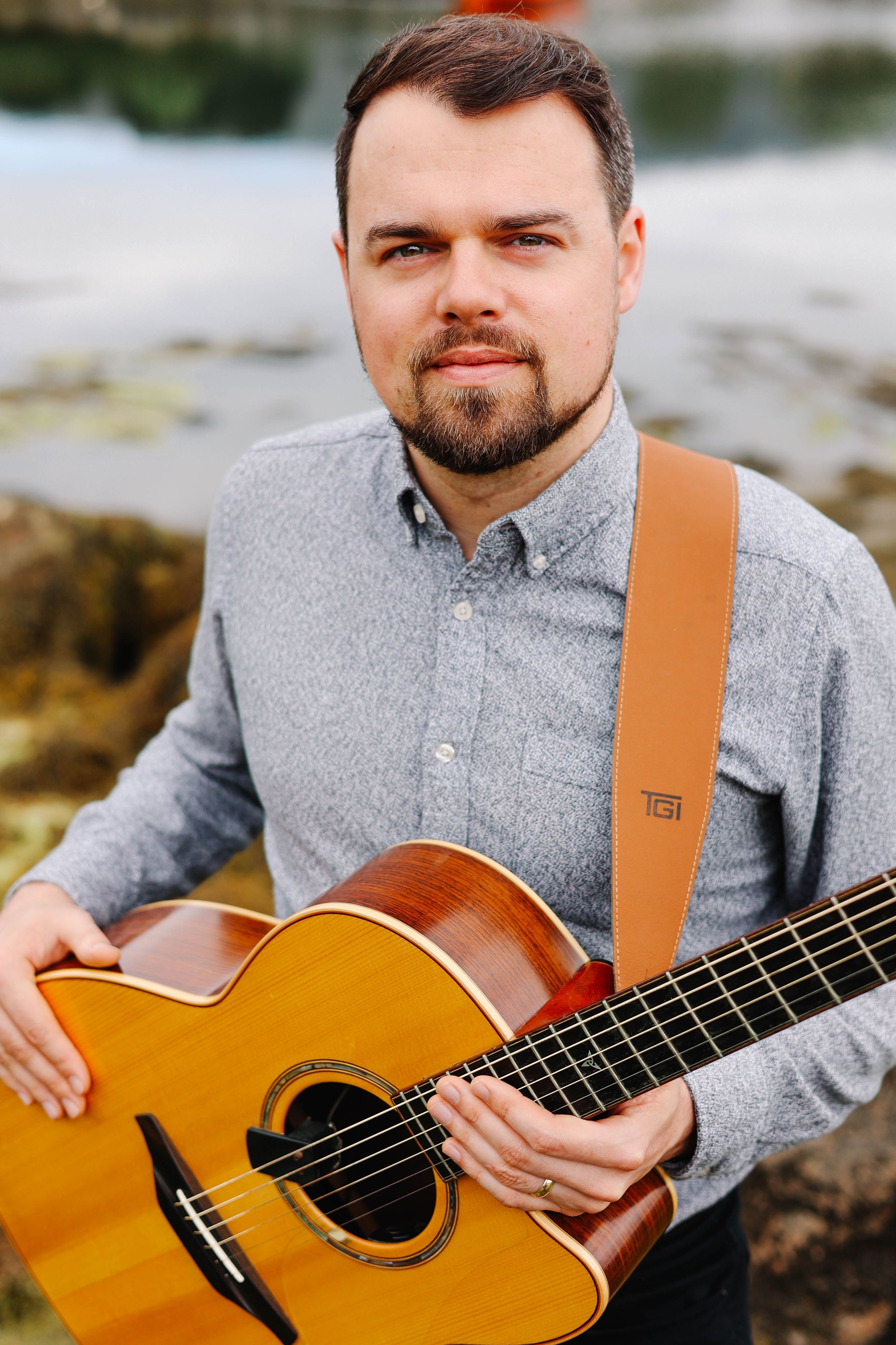 Branding photo of guitarist with instrument.