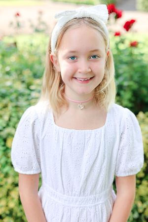Posed picture of young girl laughing in the park.