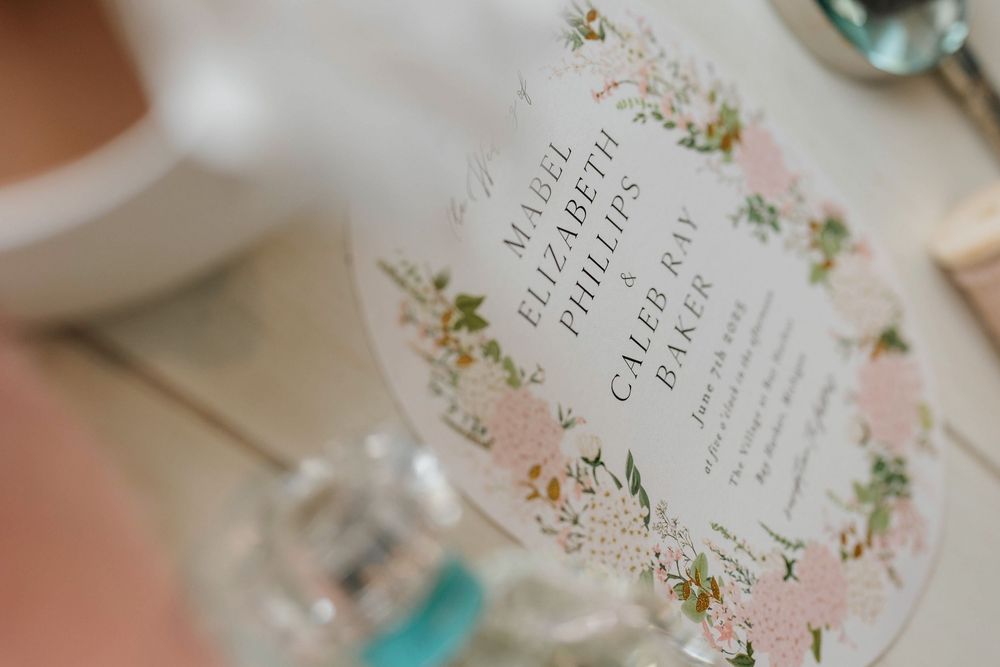 Wedding invitation cards with floral designs and elegant typography displayed in a romantic arrangement.