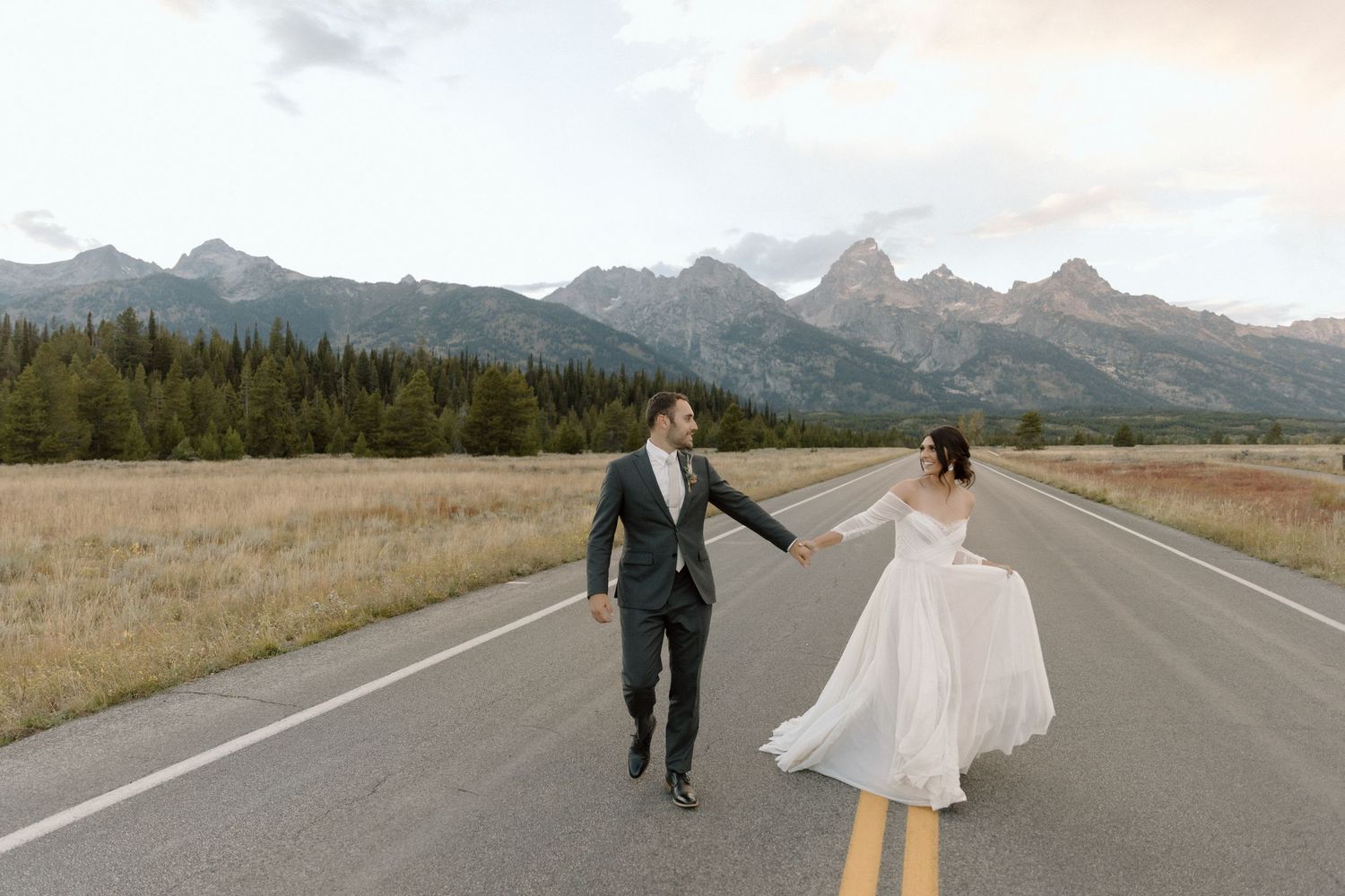 A romantic couple poses in front of the majestic Grand Teton mountains during their wedding photo session. destination photographer