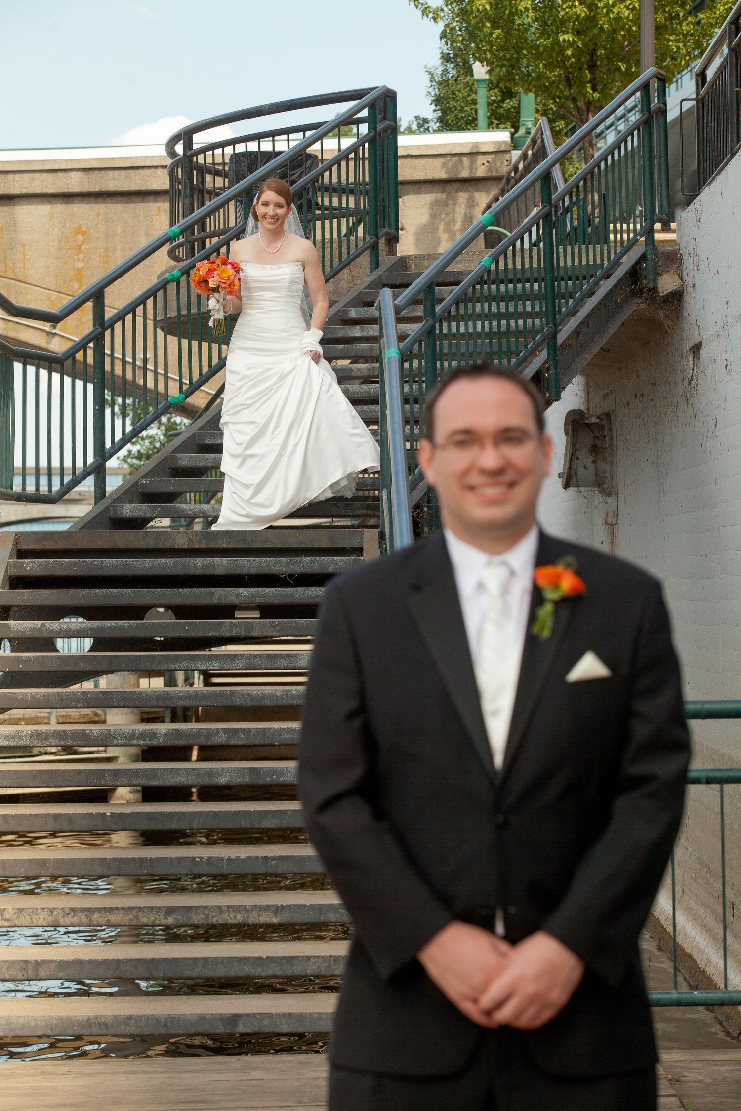 Wedding photo sequence showing a bride descending outdoor stairs while groom waits below in a black tuxedo.