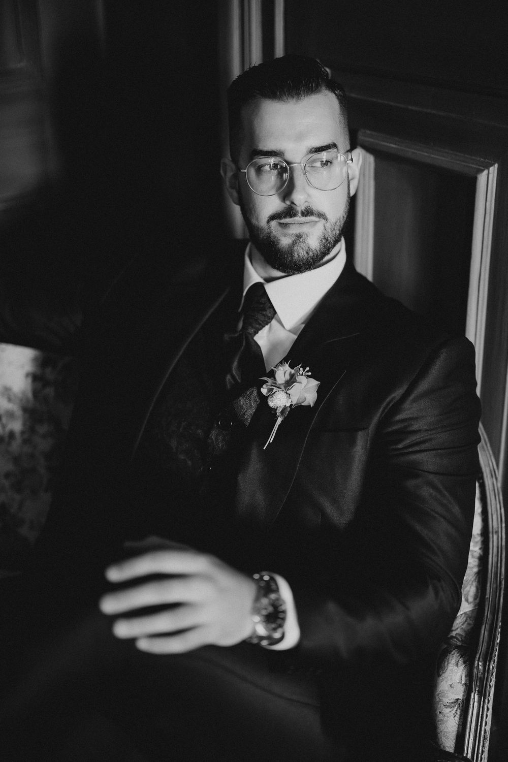 Dramatic black and white portrait series showing a person in formal attire checking their phone in moody lighting.