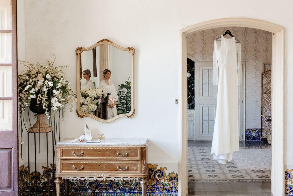 A series of vintage-style mirrors and floral decor arranged on white walls in a romantic shabby chic interior.