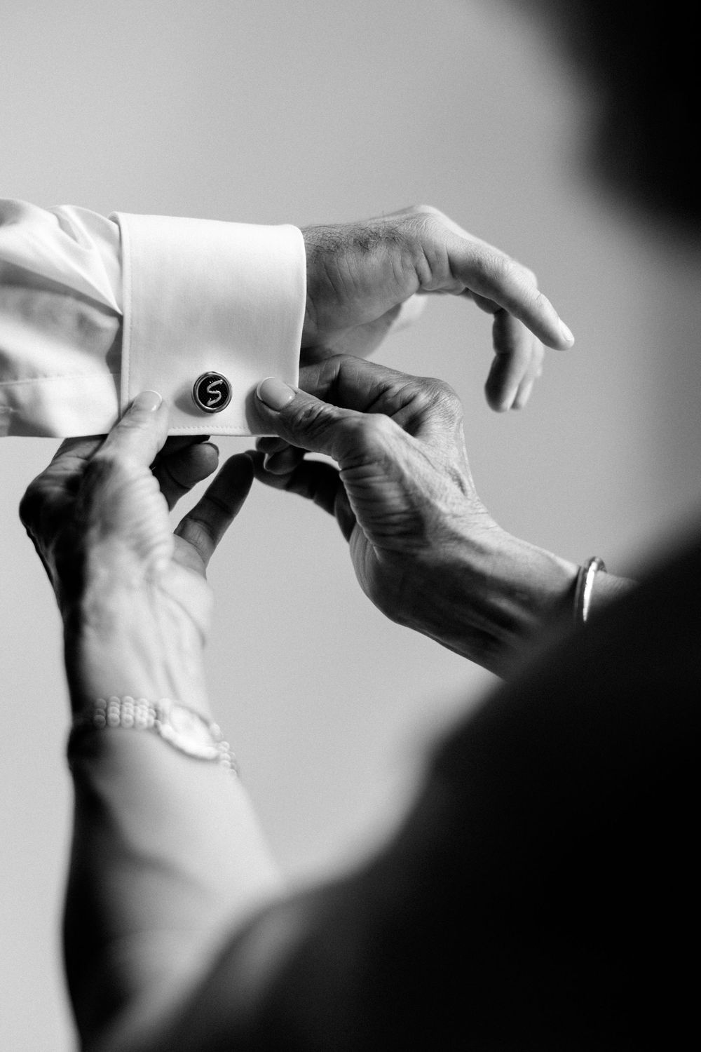 Close-up black and white sequence showing hands rolling a cigarette with loose tobacco and paper.