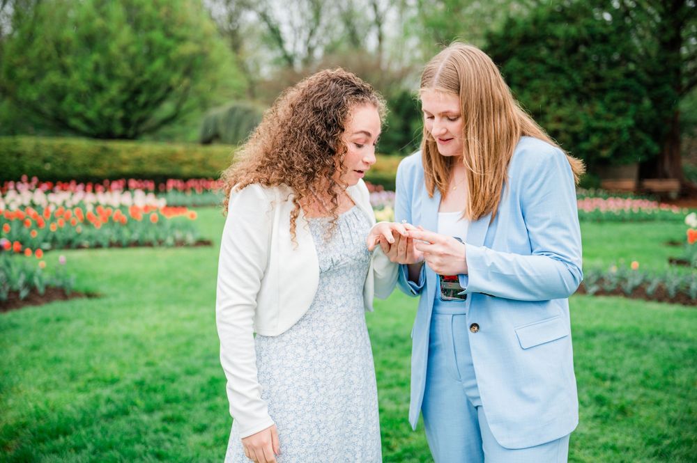 A couple sharing happy moments in a garden with colorful spring flowers.