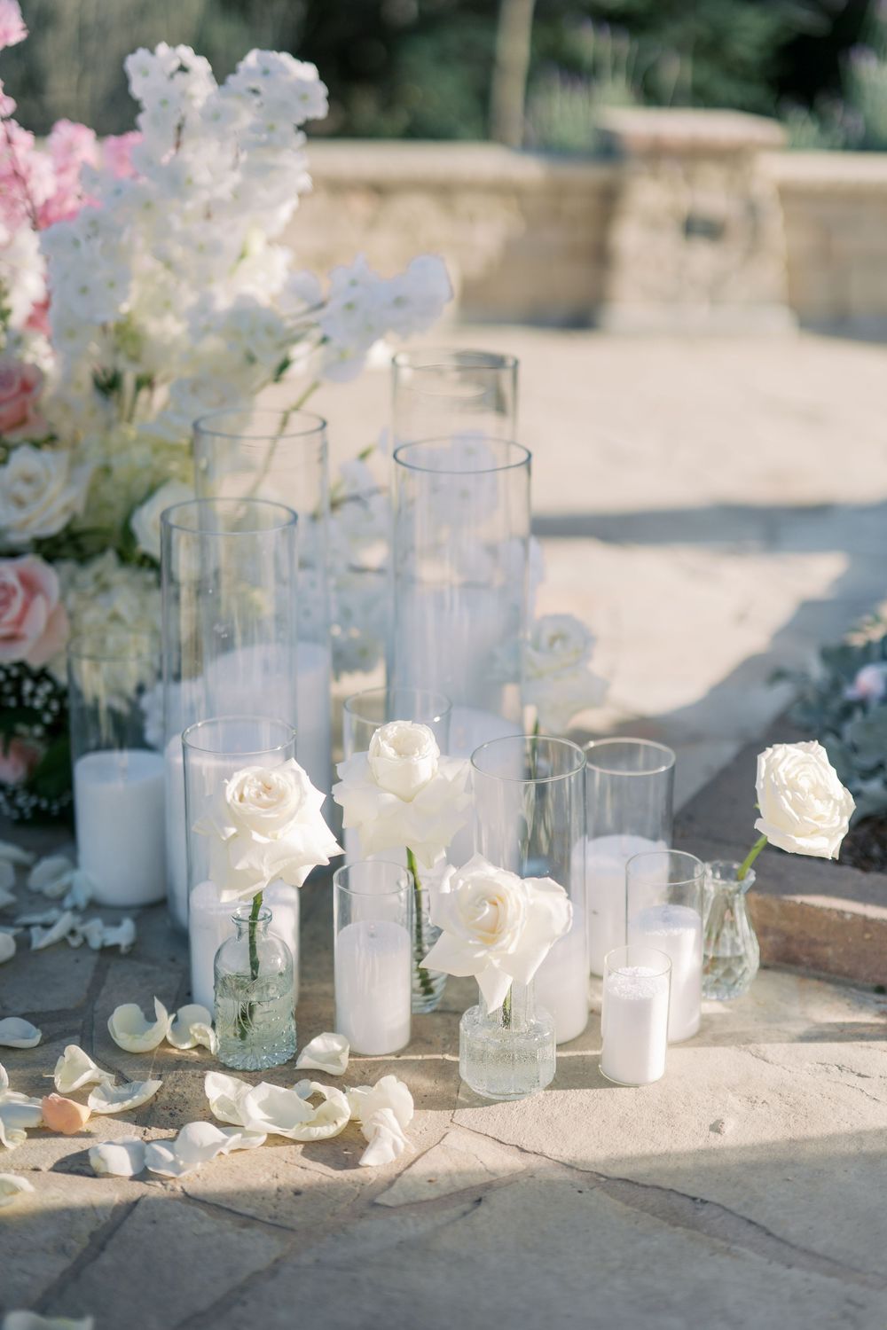 White glass vases and candles arranged in a minimalist wedding decor setting with soft natural lighting.