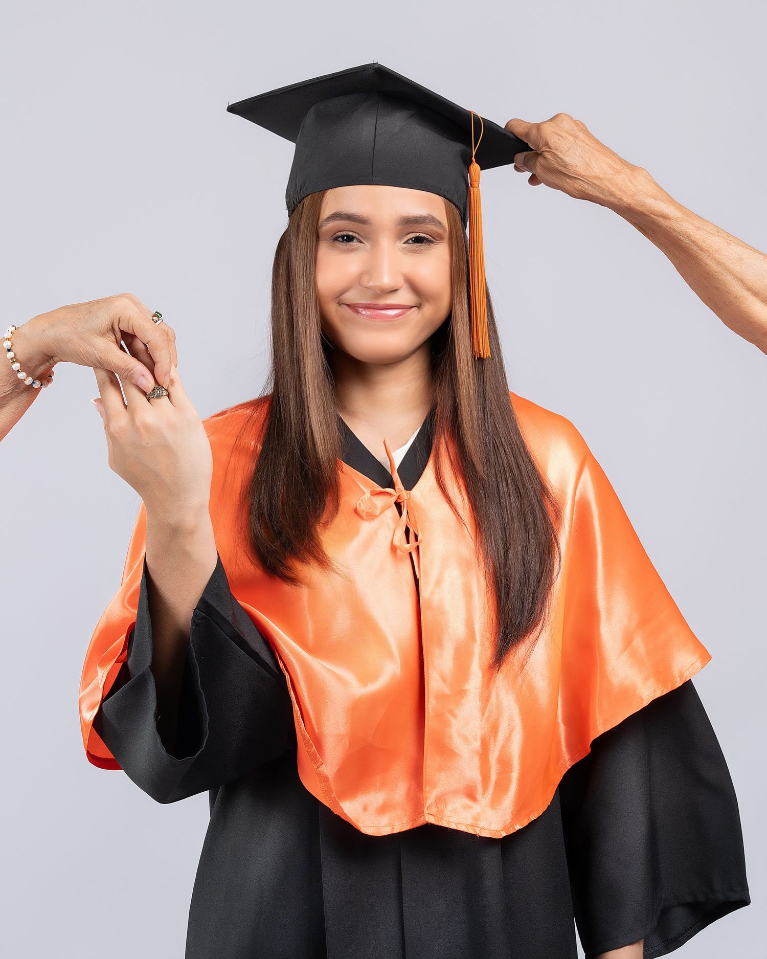 Graduate in black cap and gown holding a red diploma folder in various poses against a light background.