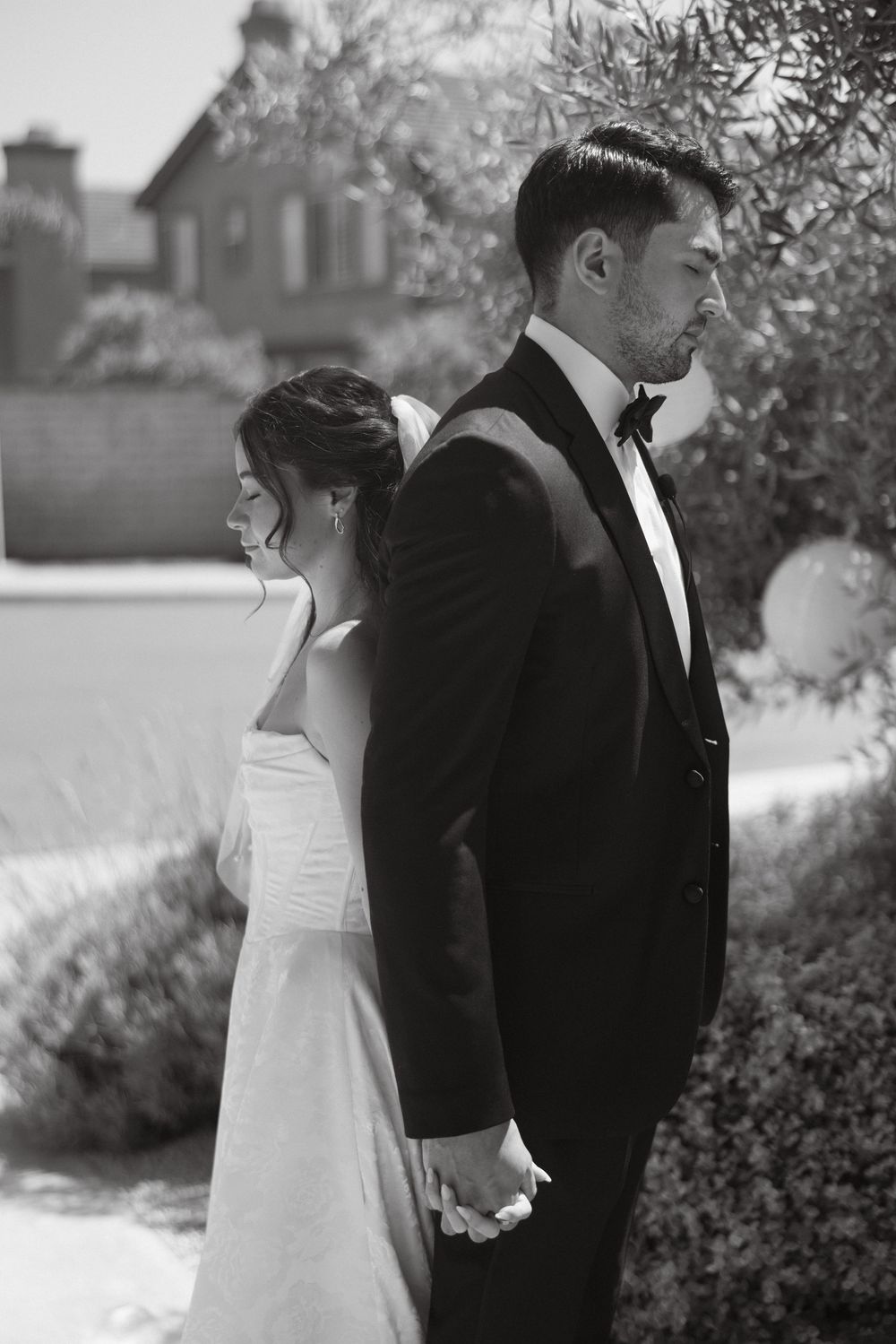 Black and white first touch moment between bride and groom before their Ventura wedding