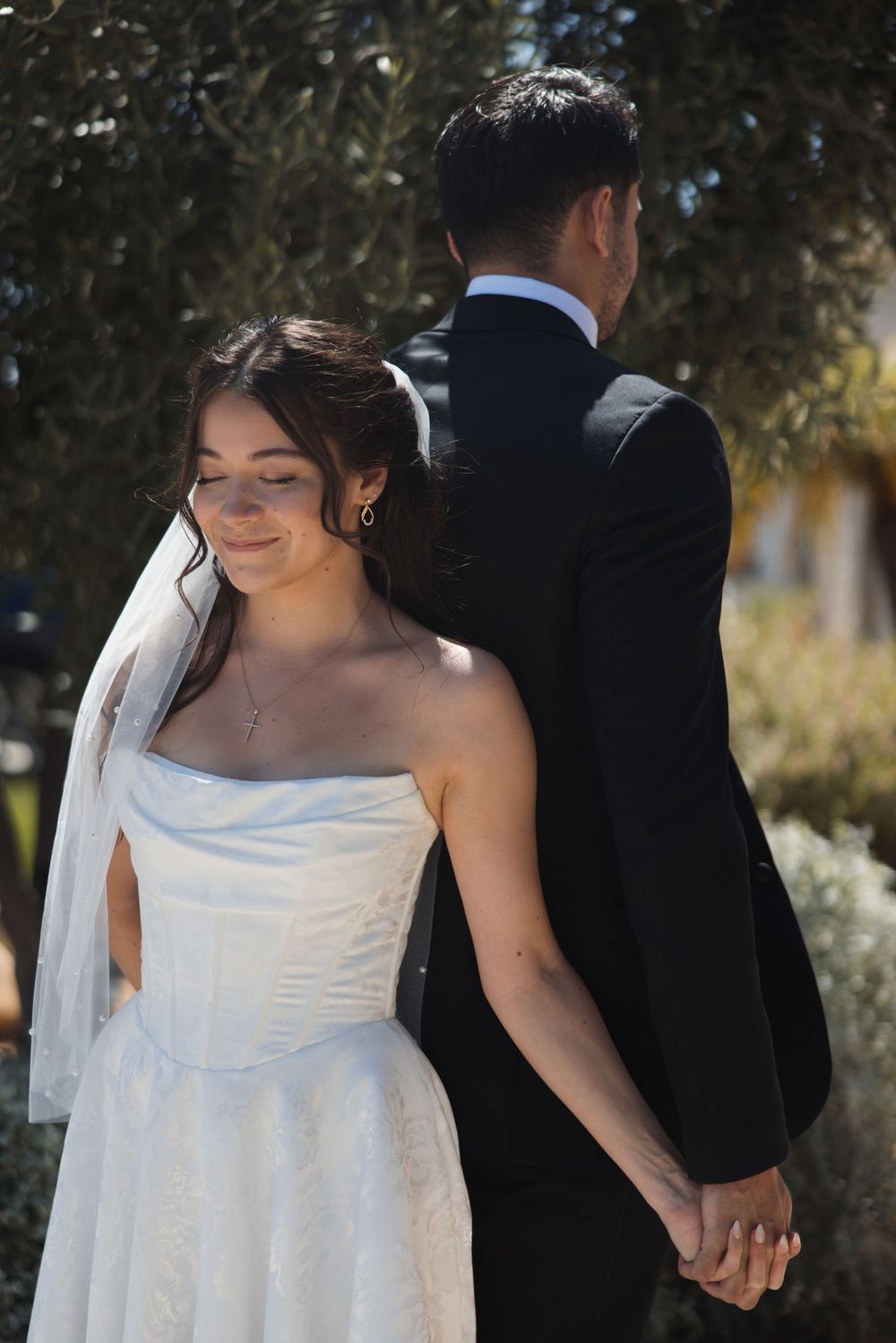 Couple holding hands during a first touch before their Ventura wedding