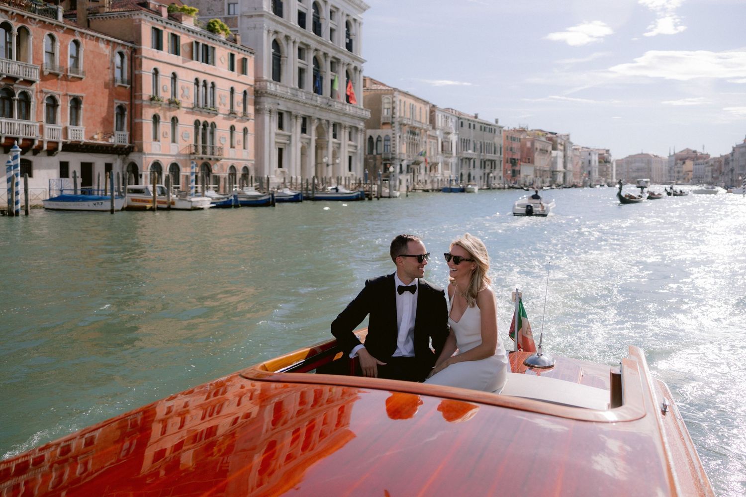 Bride and groom having a Venetian taxi boat ride along Grand Canal in Venice