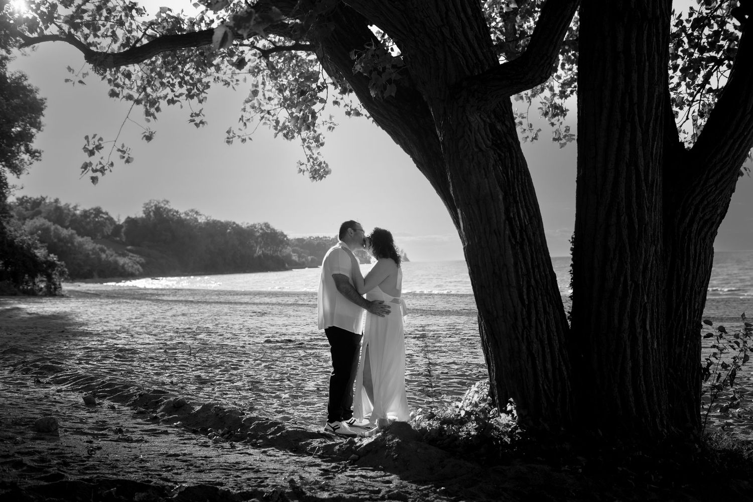 a happy couple laughing and smiling at each other while taking engagement photos. her hand on his chest while they look at each other