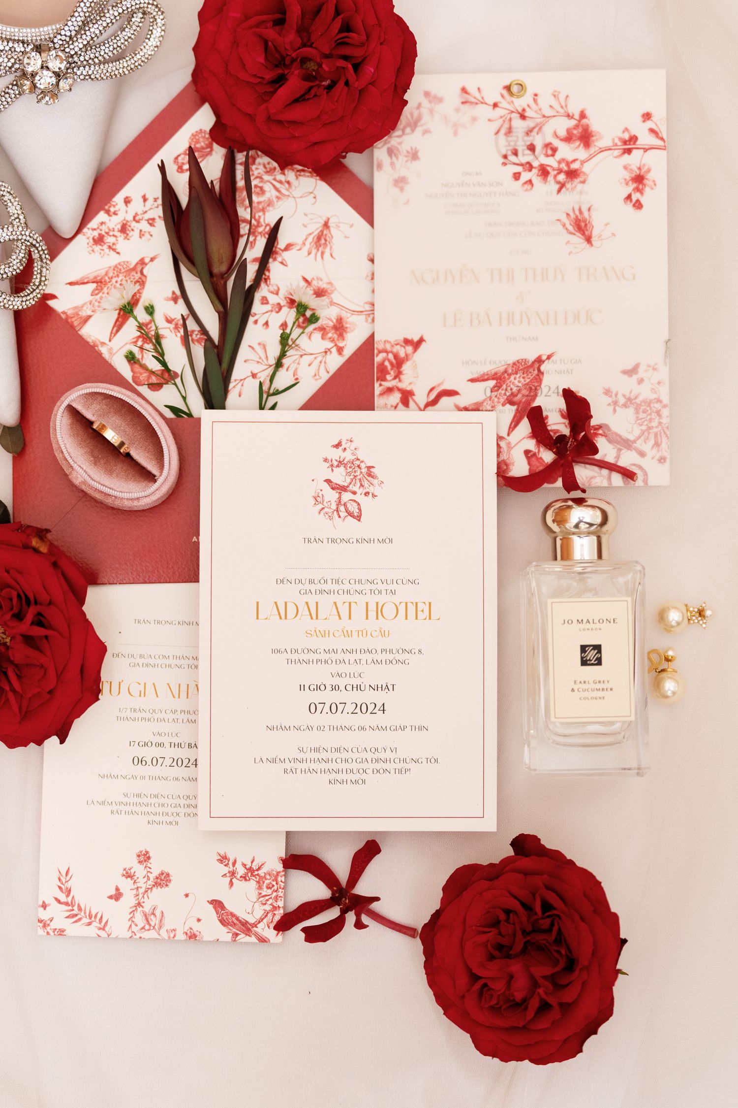 Wedding invitation suite in red and white with roses and perfume bottle.