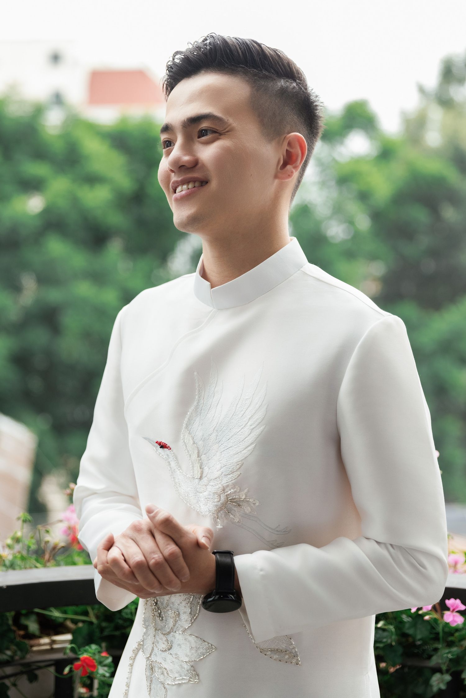 Person wearing white traditional Asian formal attire holding a decorative white bird.