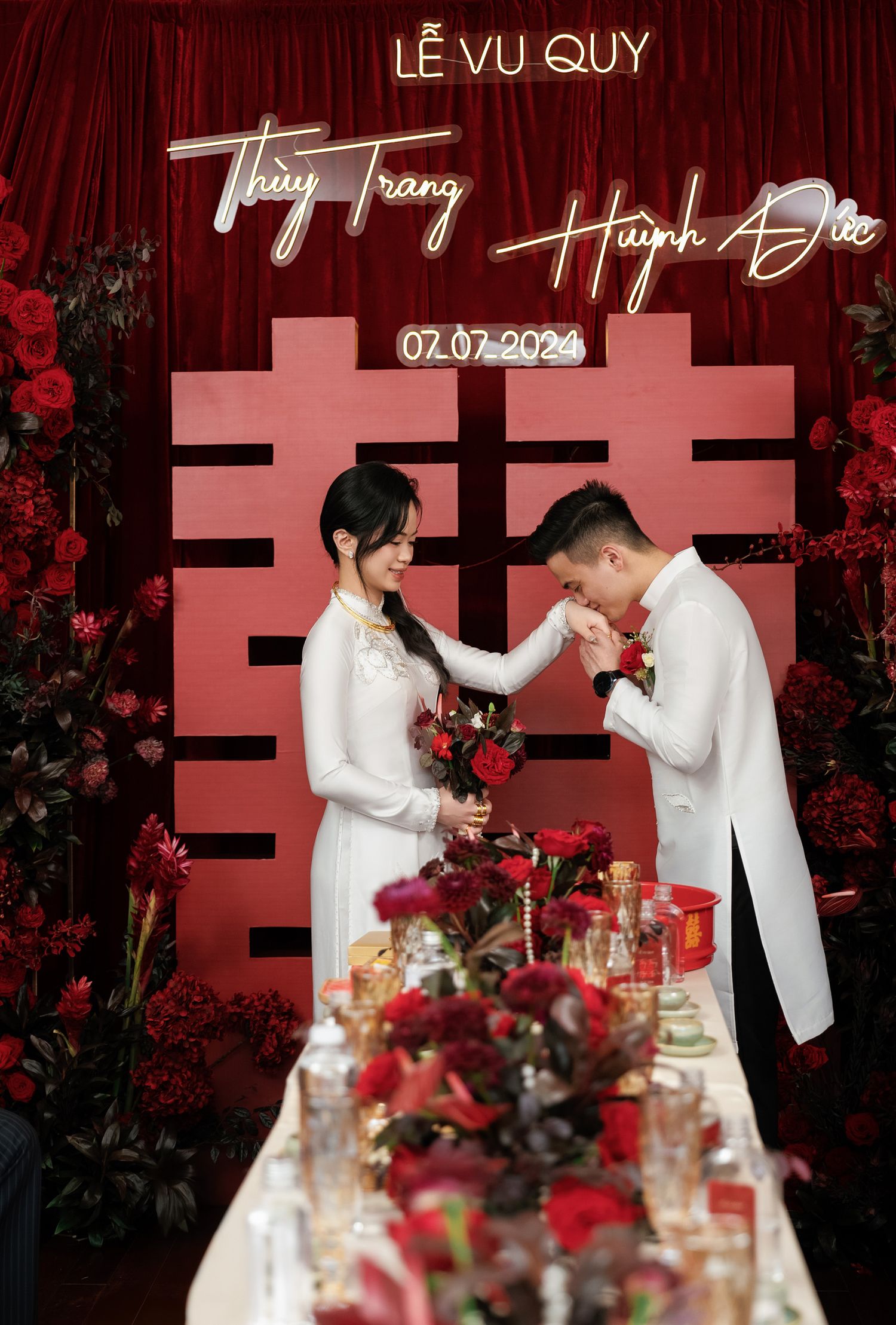 Traditional tea ceremony moment with red backdrop and double happiness symbol.