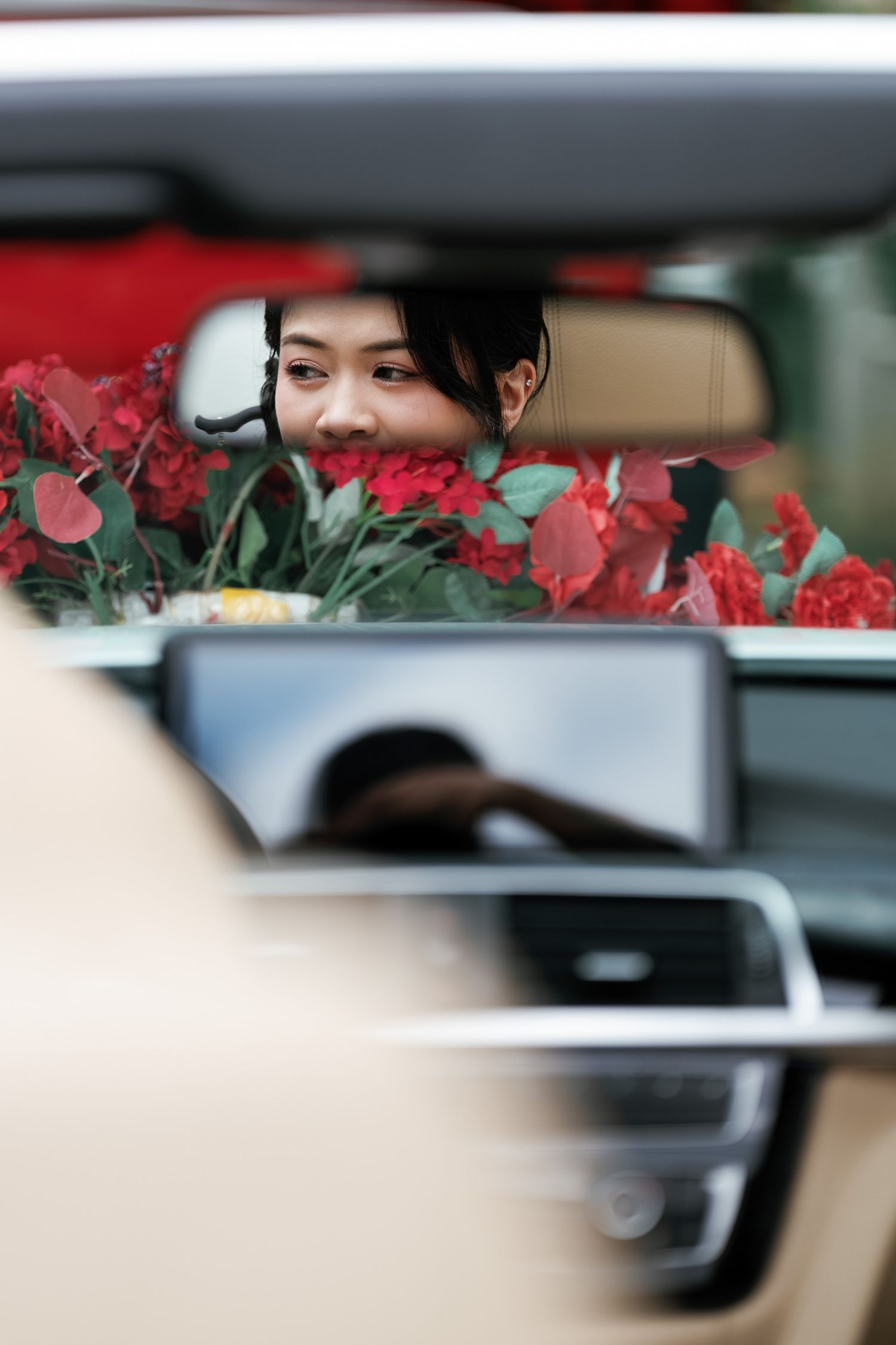 View through car mirror reflection showing wedding decorations and interior.