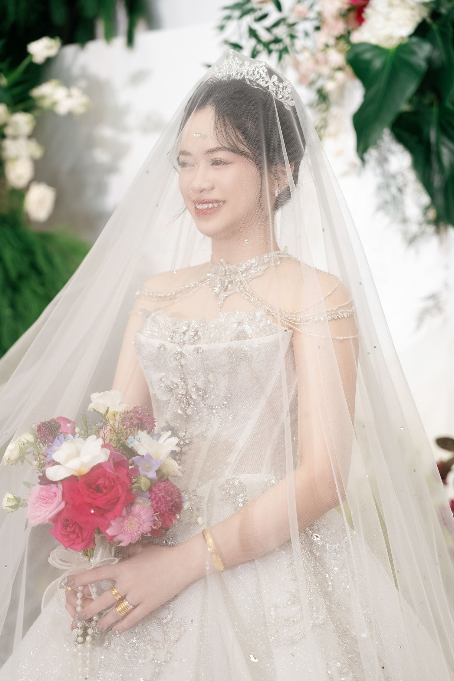 Elegant wedding portrait with lace gown and floral bouquet.