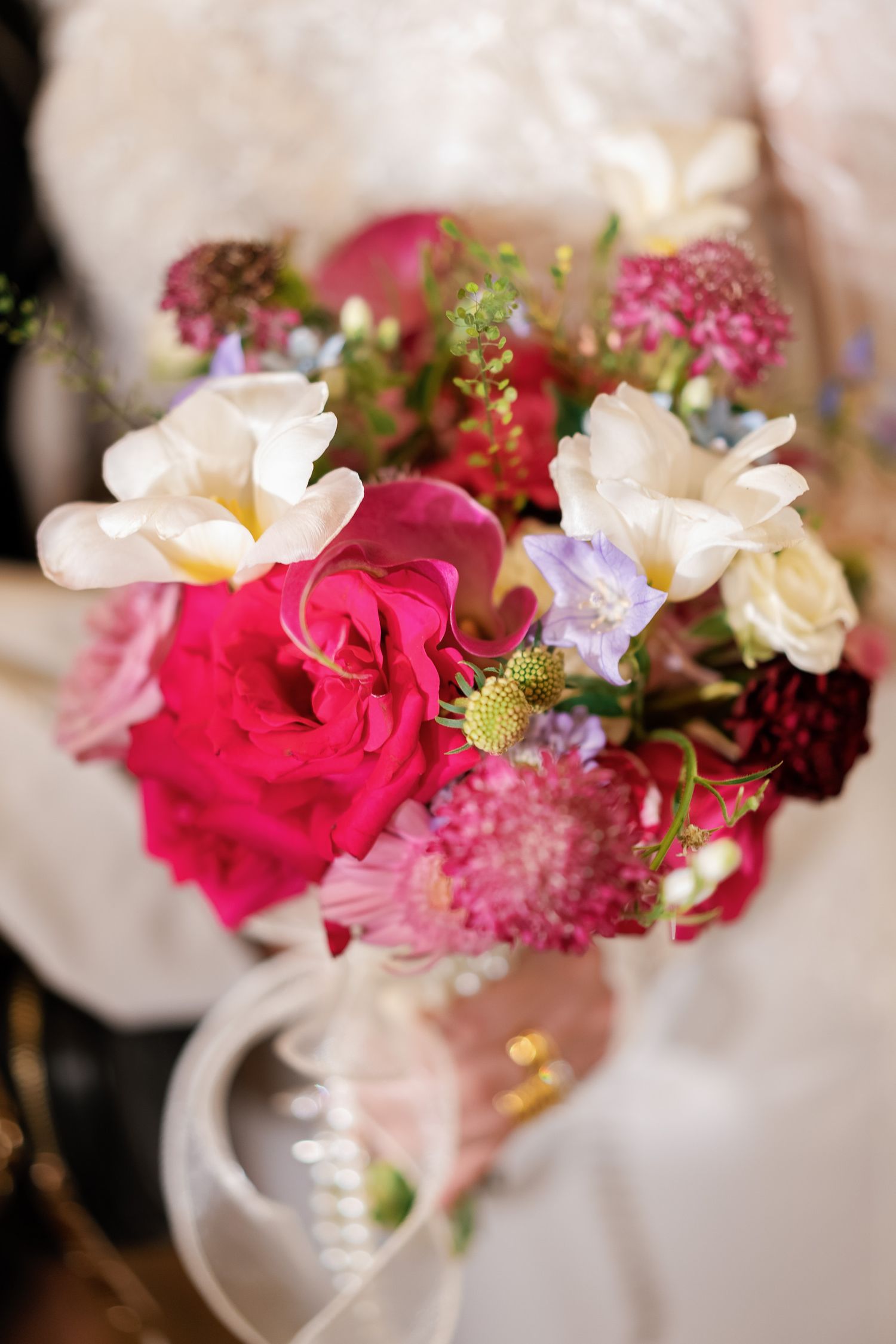 Close-up of vibrant pink roses and white flowers in an elegant bouquet arrangement.