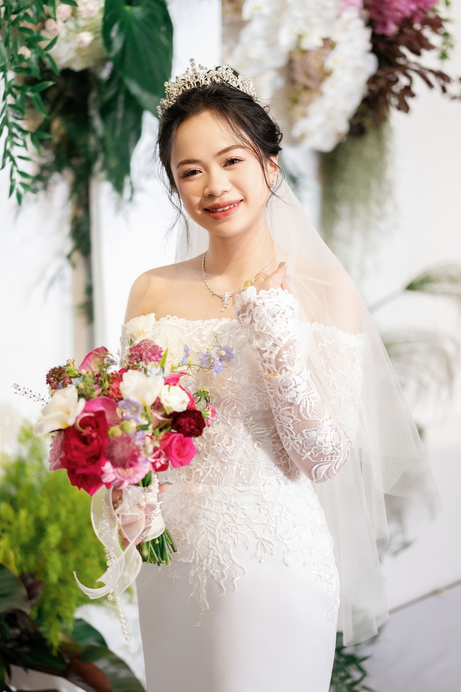 Elegant bridal portrait surrounded by luxurious floral arrangements in pink and white.