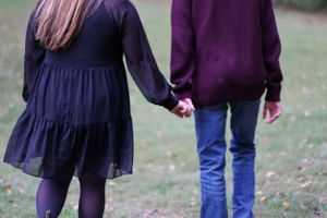 Couple holding hands walking away from the camera