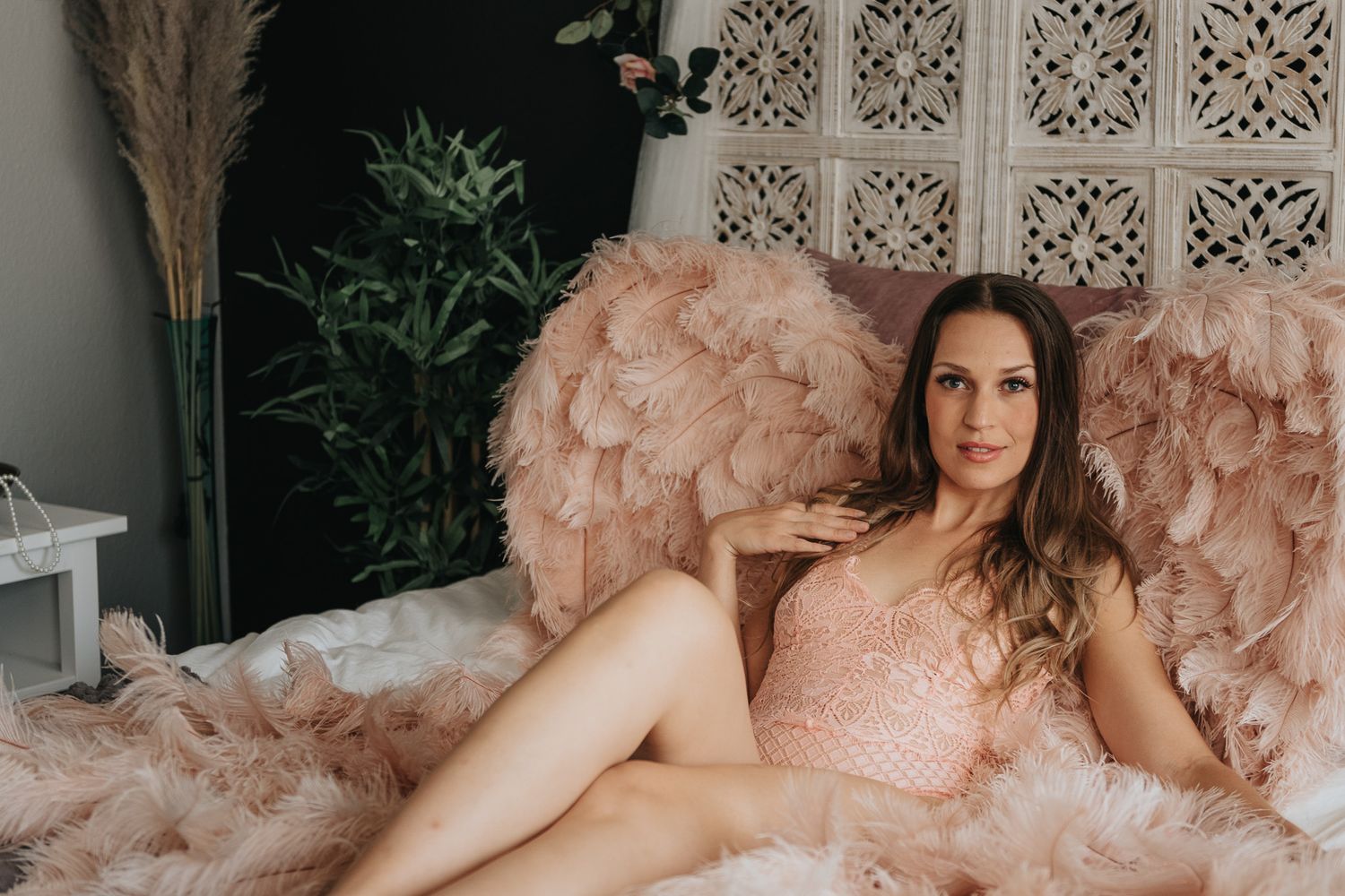 Kund i fina underkläder med änglavingarna, under sin boudoir fotografering hos Photo By Jane