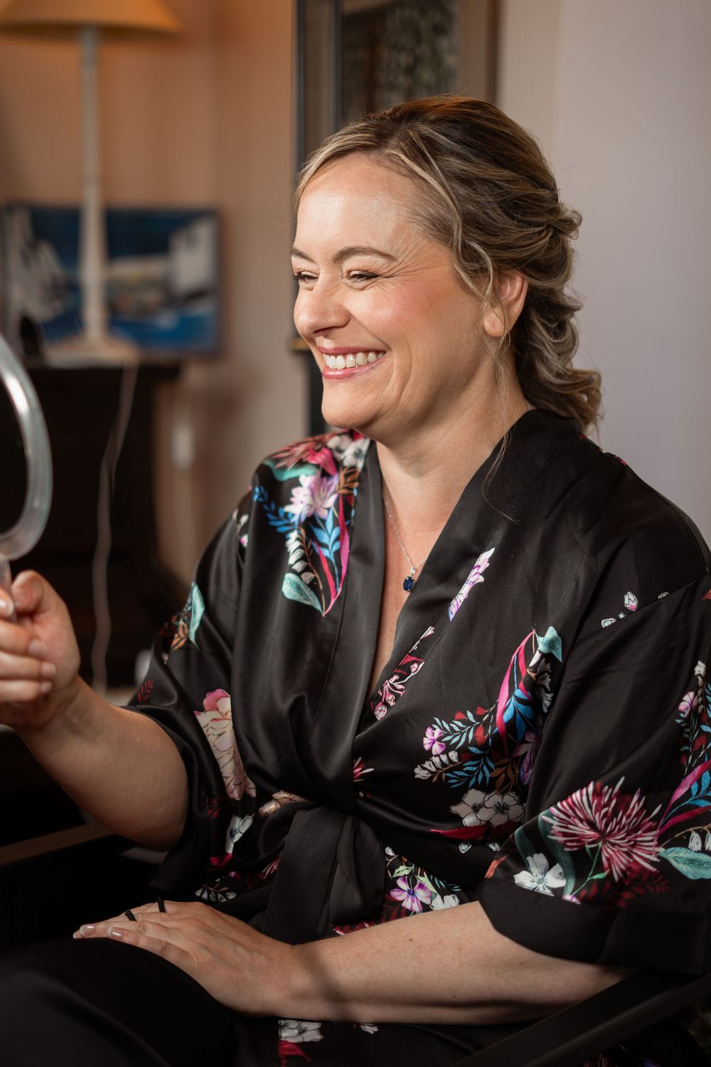 A series of photographs showing a person in a black floral robe smiling and laughing during a relaxed indoor session.