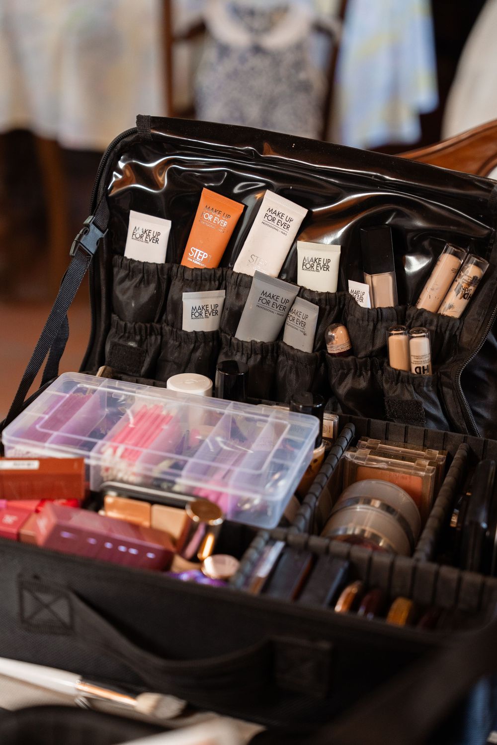 Professional makeup artist kit with organized cosmetics, brushes and beauty supplies in a black travel case.
