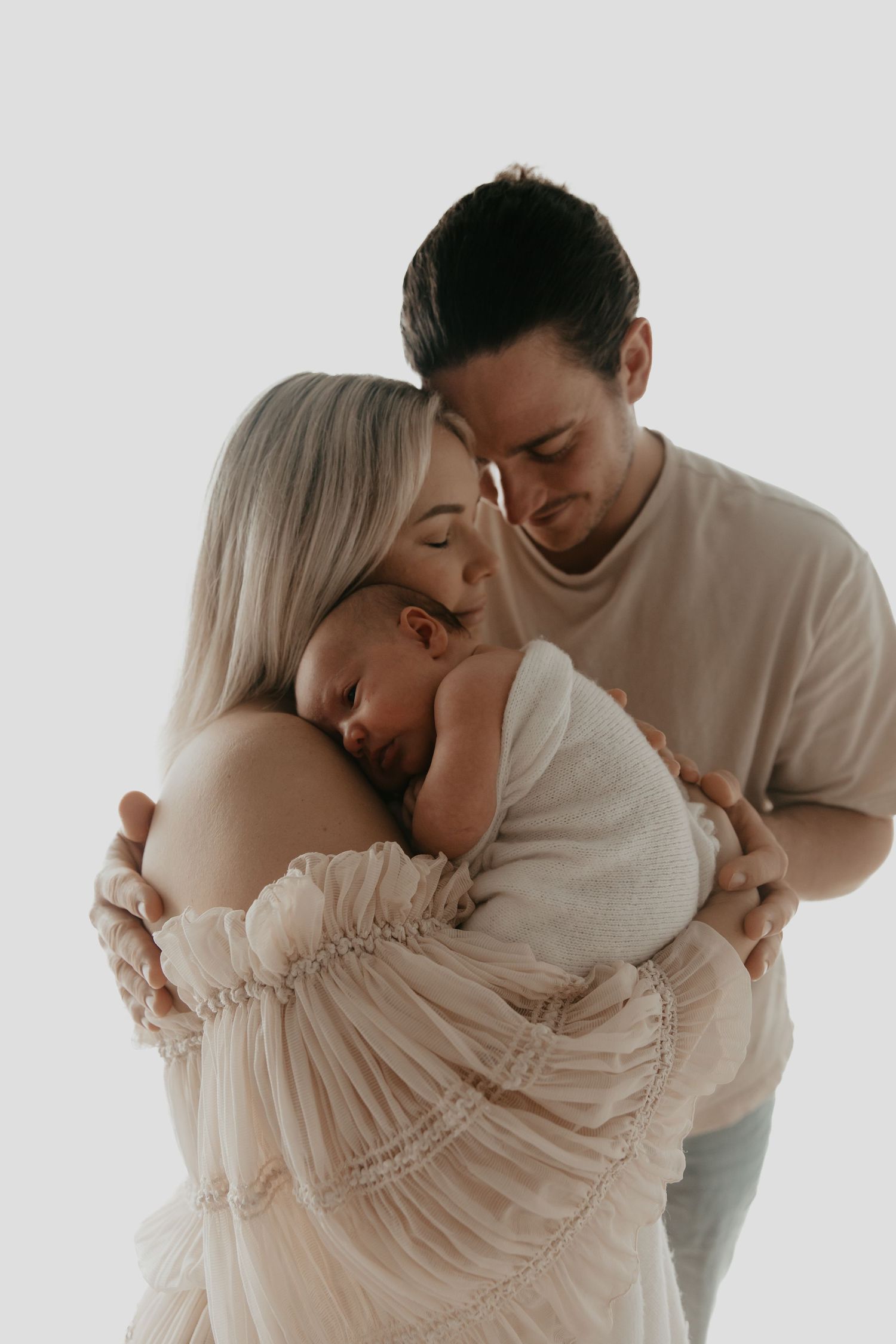 Intimate couple photography session against white background in neutral tones.