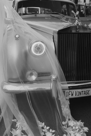 Vintage car hood ornaments in black and white showing ornate details and chrome finishes.