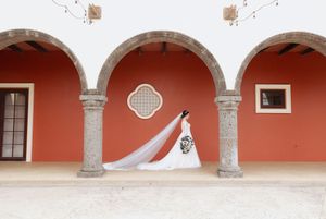 A Spanish colonial style courtyard with red arches, stone columns and white architectural details.