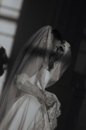 Dramatic black and white bridal portraits with delicate lace veil details in shadow.
