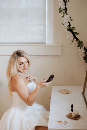 Romantic bridal boudoir scene with white dress and delicate ivy decor.