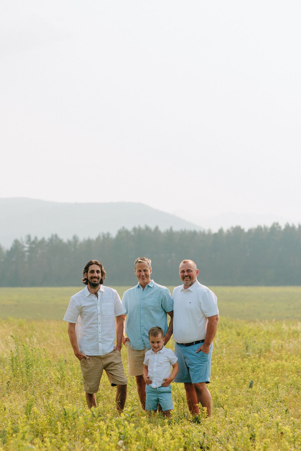 Group enjoying summer day in casual attire while walking through golden wildflower field.