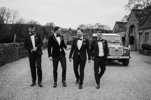 A group of people walking casually in black and white formal attire down a path together.