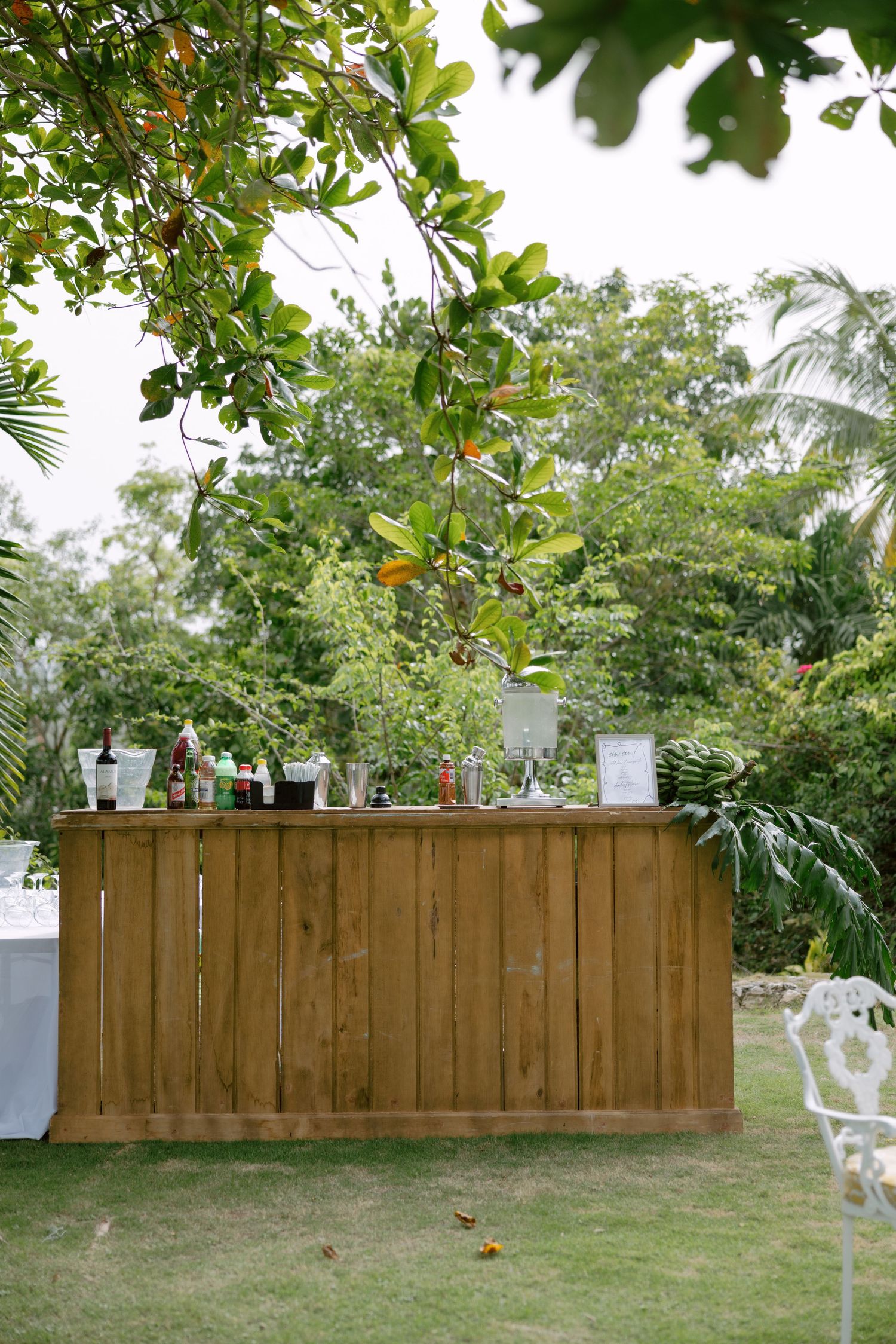 A new wooden privacy fence installation shown in multiple progress shots in a backyard with tropical landscaping.