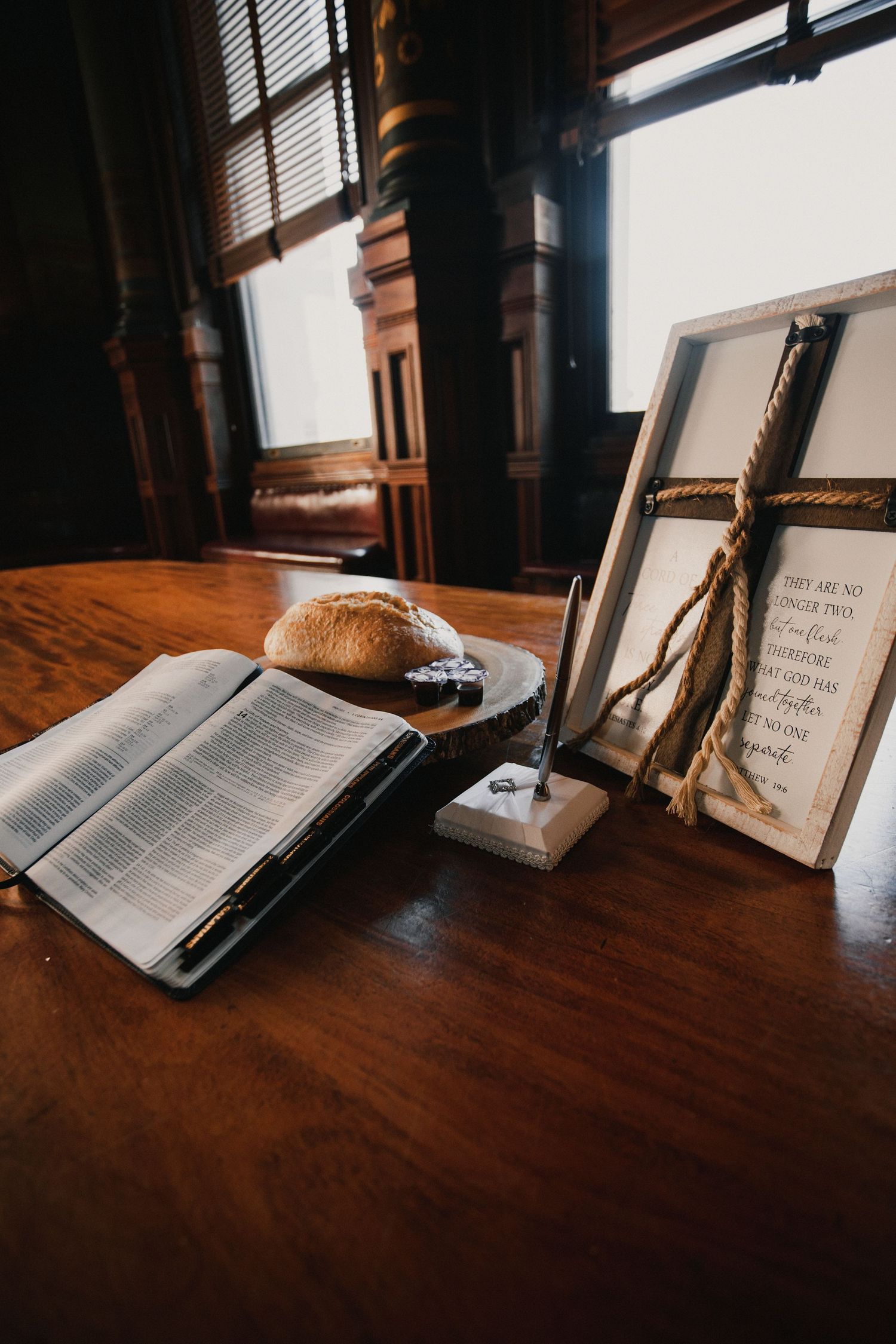 Open books arranged on dark wooden surface with natural window lighting.