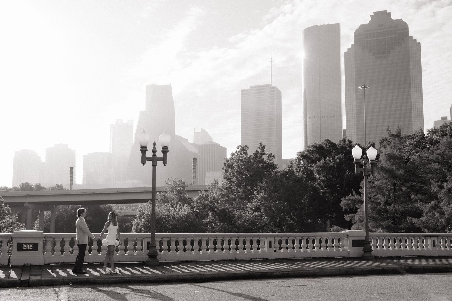 Couple sharing an intimate moment in an elegant archway setting captured in black and white.